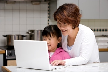 Child and adult looking at a computer