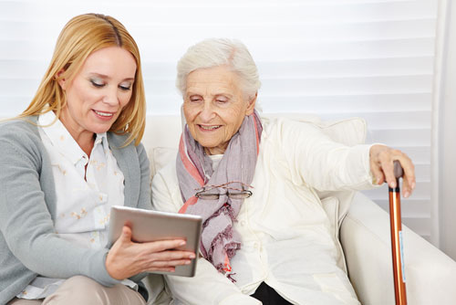 Nurse and patient looking at X-Plain on a tablet in patient's home